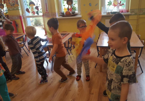 Dzieci biorą udział w zabawie ruchowej z chustą.